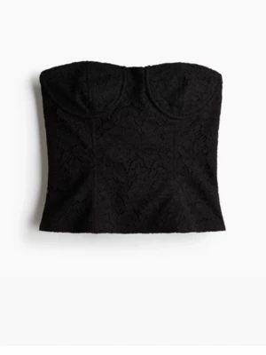 Svart spets korsettopp - Snygg svart korsettopp i spets med markerade kupor och axelbandslös design. Perfekt att styla med höga jeans eller kjol för en trendig look. Toppen har en croppad passform och fina spetsdetaljer som ger en elegant touch.