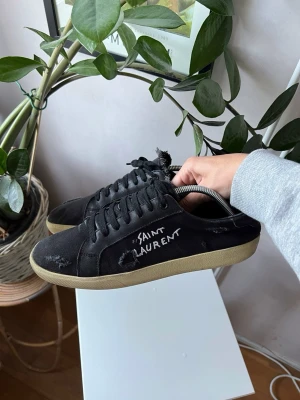  Saint Laurent sneakers - Svarta saint Laurent skor, med snygga slitningar, passar till alla outfits, låga platta sulor som gör dem väldigt bekväma gemfört med andra skor, inga skador i gott skick, skokartong inklusive dustbags ingår. 