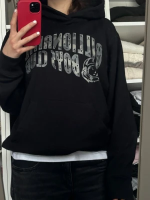 Svart Billionaire Boys Club hoodie - Snygg svart hoodie från Billionaire Boys Club med stor logga och astronaut-tryck på bröstet. Klassisk huva och magficka framtill. Köpt för 2000 kronor säljer för 900. Öppen för förhandling vid snabb affär!😇#BillionaireBoysClub 