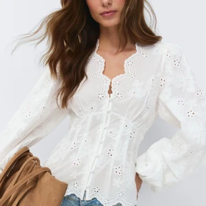 balloon sleeve blouse - Söt vit blus med broderade blommor och spetsdetaljer. Blusen har lång ärm, figurnära passform och knappar framtill. Helt slutsåld på hemsidan. Använd endast en gång.🥹💗💗