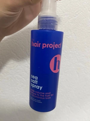 Sea salt spray från The Hair Project - Blå sprayflaska med rosa text från The Hair Project. Sea salt spray som ger volym och textur till håret för en fylligare look. Innehåller aloe vera och pepparmint. Flaskan rymmer 150 ml och har en praktisk sprayfunktion. Mängd kvar ser ni i bilden ❣️ typ 75 ml eller lite mer!
