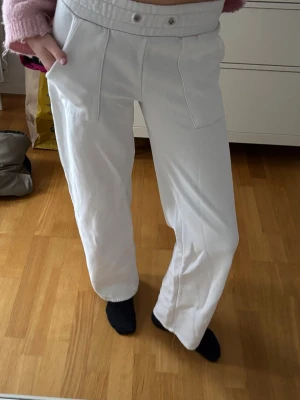 Vita vida byxor med resårmidja - Säljer ett par vita byxor med bred resår i midjan och raka, vida ben. Köpta från lager 157.