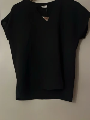 Svart v-ringad topp från JDY - En stilren svart topp från jdy med v-ringning och lös passform. 