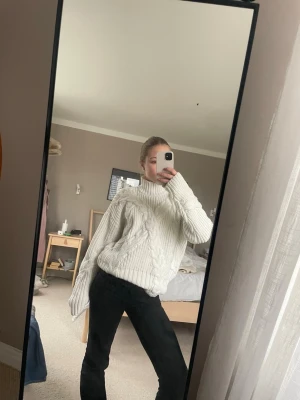 Vit kabelstickad polotröja - Säljer en oversized vit kabelstickad polotröja med grovstickat mönster och breda ärmar. Tröjan har hög krage och ribbade muddar. Perfekt för kalla dagar och riktigt mysig att bära. Sminkfläck på insidan av polon men syns inte utifrån.💕💕