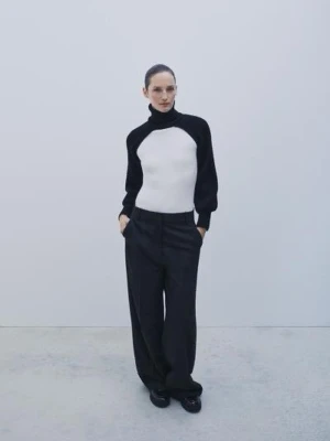 KORT OCH STICKAD KOFTA MED HÖG KRAGE - Snygg polotopp i svart med lång ärm. Koftan har hög krage och är tillverkad i stickad bomull.