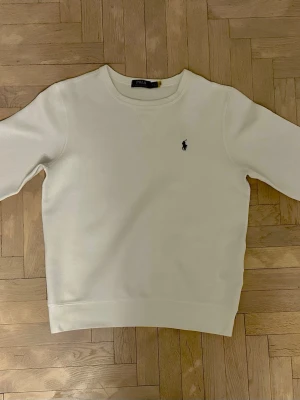 Ralph Lauren sweatshirt  - Säljer en vit Ralph Lauren sweatshirt i bra skick. Använd ett par gånger men fortfarande fräsch. Enkel modell som passar till det mesta och alltid är rätt.  Hör av dig om du är intresserad.