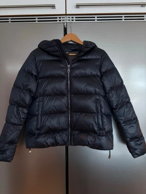Marinblå Colmar dunjacka - Säljer en marinblå dunjacka från Colmar. Jackan har inga defekter och den är knappt använd. Den är perfekt för både vinter och höst. Nypris är 6999 kr. Storlek 42 men liten i storlek så jag skulle säga att den är som en S. Jackan har även en dragkedja vid huvan så den går att ta bort om man skulle vilja det