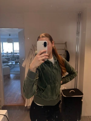 Juicy Couture Grön velour hoodie med dragkedja - Mysig grön hoodie i velour med dragkedja framtill och huva. Zip Hoodien är från Juicy Couture och är i färgen Duck green, är i storlek Xl. Tog i en större storlek för att inte ha den så tajt, har även liknande set i storlek S. Perfekt skick, använt enstaka gång. Tyvärr har jag tagit bort prislappen, annars hade den nästan varit som ny. Nypris för denna hoodien är för 1300kr, mitt pris 800kr. Skriv för fler bilder eller för intresse? Eller vad ni kan ge för denna hoodien. Finns i Norrköping. 