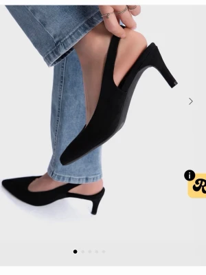 Svarta slingback-pumps med klack - Stilrena svarta pumps med spetsig tå och öppen häl i slingback-modell. 