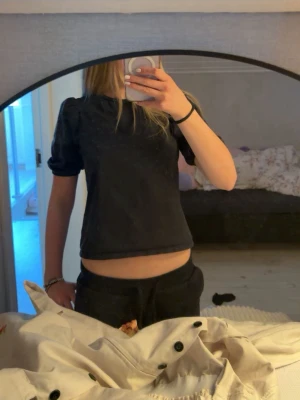 Svart topp med puffärm från lager157 - Säljer en svart topp från lager157 med puffärmar och rund hals. Toppen är croppad och har en enkel, stilren design som passar till det mesta. Tillverkad i mjuk bomull för en bekväm känsla.