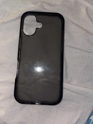 Transparent iPhone 17 mobilskal från Holdit - Snyggt transparent mobilskal från Holdit med svart kant. Skalets material är tålig plast och det har en stilren design som visar upp din mobil. Passar perfekt för dig som vill ha ett diskret men skyddande skal. Kan gå ner i pris 