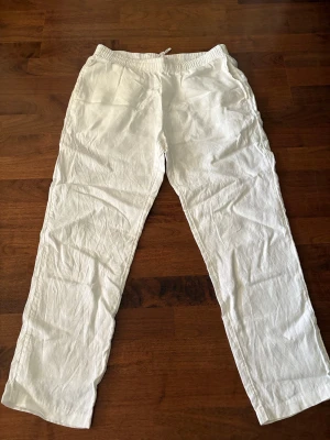 Vita linnebyxor - Snygga vita linnebyxor med avslappnad passform. Perfekta nu inför sommaren. Byxorna är k stolen M och passar dig som är 170cm-185cm. 