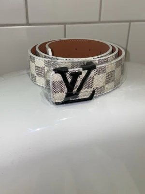 vit bälte - Snyggt vit bälte med rutigt mönster. Passar till alla outfits!!