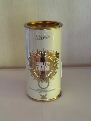 Jean Paul Gaultier Divine parfym - Snygg parfym från Jean Paul Gaultier i en lyxig, guldig cylinderformad förpackning med metallisk finish och detaljer i guld. Förpackningen har en cool design med texten 'Gaultier Divine' och är inköpt på Sephora.