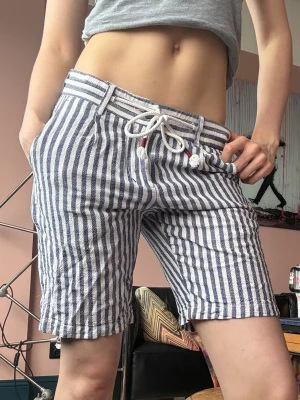 Randiga blåvita shorts med snörning - Snygga shorts, perfekta för sommaren och tillverkade i ett lätt bomullstyg. Buda gärna priser!