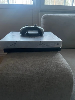 XBOX ONE X: GEARS 5 LIMITED EDITON KONSOL + 1 HANDKONTROL - Säljer en Xbox One X gears 5 Limited Edition med unik grå och svart design med sprickmönster. En svart handkontroll ingår. Perfekt för gaming och streaming. 