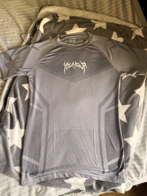 Compression shirt YoungLA stl S - Snygg grå sporttröja från YoungLA med korta ärmar och tryckt logga i vitt framtill. Tröjan har ett sportigt mönster och är gjord i ett lätt och stretchigt material som andas, perfekt för träning eller gymmet. Sitter tight storlek S