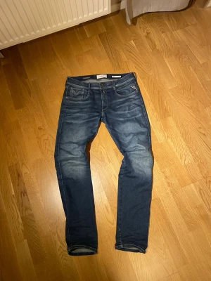 Replay Anbass Jeans - Replay jeans i modellen Anbass som motsvarar slim fit. Jeansen är fria från defekter och är i ett ofantligt bra skick. Storleken är 34/34.