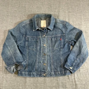 Vintage Levi’s UK Made Trucker Jacket Cropped Size M - Clean vintage Levi’s trucker with a cropped boxy fit. Lighter weight denim so it’s easy to wear, not heavy or stiff. Perfect for layering. UK made late 90s. Small mark on sleeve (only visible in bright light). measurements (cm): s2s 45, p2p 52, sleeve 58, length 56.5, waist 49