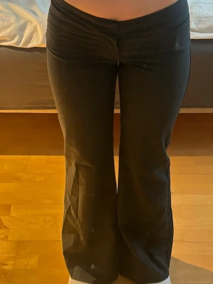 Lågmidjade kostymbyxor från Forever 21 – strl S (pinstripe) - Snygga lågmidjade kostymbyxor från Forever 21, köpta i USA. Klassisk mörkgrå färg med diskreta nålstreck (pinstripe) som ger en stilren och dressad look.  Storlek S och sitter tight/figurnära med låg midja – perfekt för en trendig Y2K/vintage vibe.  Stretchigt material som gör dem bekväma att bära. Passar lika bra till vardag med en hoodie som uppklätt med kavaj eller topp.  Originalpris: ca 600 kr Säljes i fint skick ✨