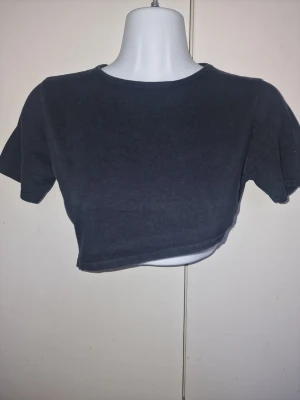Svart croppad t-shirt - Svart asymmetrisk t-shirt som är snygg över en sport bh till dans/träning. Perfekt för en avslappnad stil eller att bära under en skinn/jeans jacka.