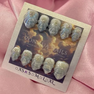 Aoi (S);Short Almond - Unika press-on naglar med handmålad mermaid design. Naglarna har en skimrande ljusbllå färg med vita detaljer och små silverpärlor och pärlor. Formen är short almond. Perfekt för dig som vill ha något kreativt och unikt på naglarna.S: 15 mm, 11,5 mm, 12 mm, 11 mm, 9 mm 