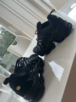 Svarta Nike Air VaporMax ÄKTA Swipa sista bilden - Nike Air VaporMax Plus sneakers i helsvart, dessa är använda 1 månad! Resten av tiden har dessa bara varit hemma, inga skador ❌