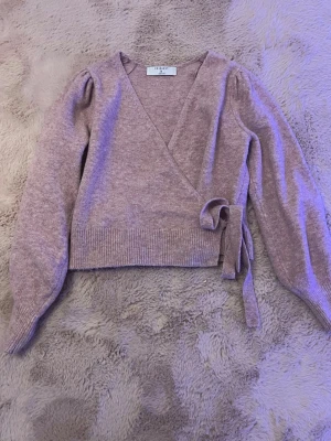 Rosa omlott stickad tröja från Primark - tröjan har långa puffärmar, ribbade muddar och knytdetalj i midjan. Perfekt för lager-på-lager och ger en söt och trendig look.