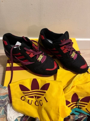 Gucci x Adidas ZX 8000 - Original från Gucci x Adidas. Riktigt bra skick. Använda men ser i princip nya ut. Ngn liten blessyr på utsidan och lite färgsläpp på innersulan.   Verifierade och med lappar kvar på lådan. Påsar och box. Hör av er vid frågor eller om ni vill ha fler bilder.  
