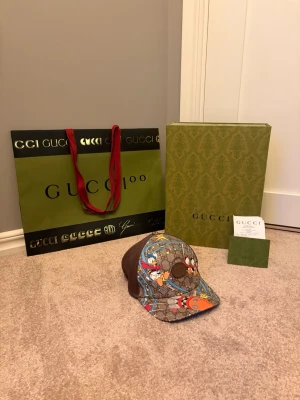 Gucci x Disney keps  - Säljer en unik Gucci x Disney keps i mycket fint skick. Kepsen är inköpt i Gucci butik i Paris för cirka 2100kr och är endast använd ett fåtal gånger. Självklart följer allt tillbehör med till kepsen som box, påse, kvitto m.m. Kepsen gjordes endast i en begränsad upplaga och finns ej att köpa ny längre. Det är bara att höra av sig vid minsta fråga! 