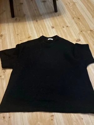  oversized stickad tröja Gina  - En svart oversized stickad kortärmad tröja från Gina. Har krympt lite smått i tvätten passar fint både de som bär M och L. Ord. Pris 399kr