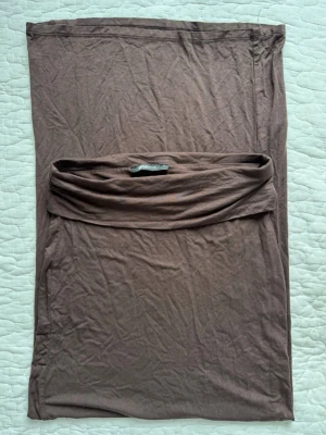 Brun kjol - Brun kjol från Gina tricot i mjukt och stretchigt material. Jag skickar inte fler bilder utan det är detta som syns, pga alla kläder ligger i flyttlåda. Kjolen är helt oanvänd och har legat i garderob sedan förra sommaren. 