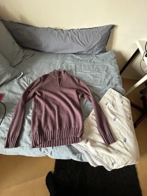 Lila stickad tröja från Dressmann - Säljer en lila stickad tröja från Dressmann med ribbad krage och muddar. Tröjan har lång ärm och är tillverkad i ullblandning, perfekt för kyligare dagar. Enkel och stilren design som passar till det mesta.