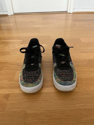 Nike Air Force 1 Flyknit – multicolor – Storlek 38,5 - Nike Air Force 1 Flyknit Multicolor i storlek 38,5 säljes. Riktigt snygg och ovanlig modell med färgglad Flyknit-design och klassisk Air Force-sula. Skorna är lätta, bekväma och enkla att matcha till många outfits. De är i gott använt skick med normalt slitage som visas på bilderna.