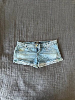 Lågmidjade jeansshorts - Säljer dessa jättefina jeansshorts med lågmidja i ljusblått. Shortsen är från killah och sitter jätteskönt. Fråga om mått! Obs: Finns svaga rosa fläckar på insidan! (se sista bilden)