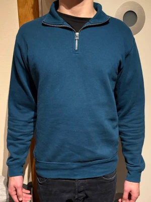 MÖRKBLÅ HALFZIP FRÅN ZARA - Mörkblå sweatshirt med halv dragkedja från Zara. Tröjan har hög krage, långa ärmar och ribbade muddar vid ärmslut och nederkant. Tillverkad i mjukt sweatshirtmaterial som är skönt mot huden. Enkel och stilren design som funkar till många looks.                                                                             (Modellen är 180cm, 72kg)