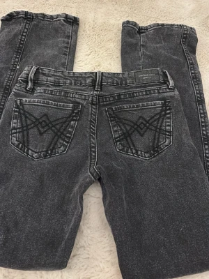 Svarta jeans från Gina Tricot - Säljer ett par svarta 'perfect jeans' från Gina Tricot med snyggt tvättad look och dekorativa sömmar på bakfickorna. Klassisk femficksmodell med bälteshällor och raka ben. Perfekta för dig som gillar en avslappnad men trendig stil.