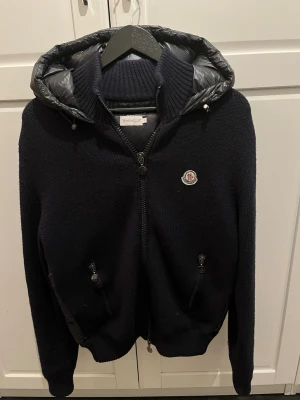 Moncler Tricot cardigan - Säljer en fet sälsynt Moncler Tricot Cardigan med glansig luva, perfekt för alla årstider och sommarkvällar. Jackan är i bra skick utan synliga skador, och är ute ur produktion. Priset är inte hugget i sten och kan diskuteras vid snabb affär. 