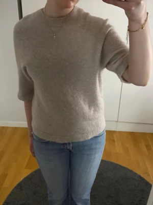 Beige stickad tröja & Other Stories - beige stickad tröja från & Other Stories. Tröjan har halvlånga ärmar. Storlek xs men passar S 