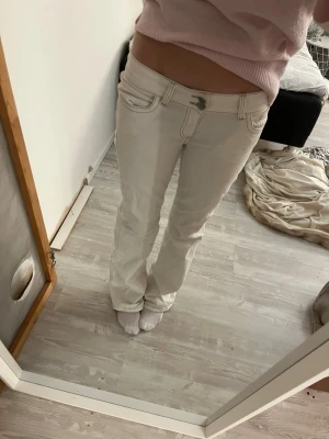Vita bootcut jeans med broderi - Säljer ett par vita jeans från Nelly, har ej använt dem ungefär max 5 gånger. Jeansen har låg midja, och har då ett högre pris eftersom dem inte finns att hitta på Nelly längre . Perfekta för dig som vill ha en clean och fräsch look.