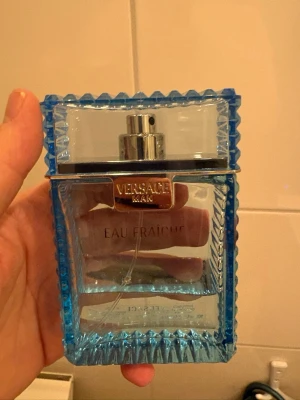 Versace Man Eau Fraîche parfym - Fräsch parfym från Versace, Man Eau Fraîche, i en stilren och lyxig blå glasflaska med räfflade kanter och silverdetaljer. Flaskan har en rektangulär form och sprayfunktion. Perfekt för dig som gillar exklusiva dofter. Ca 33% kvar.