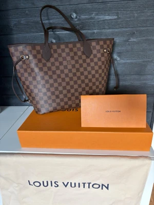 Louis Vuitton Neverfull MM – Oanvänd - Väskan är helt oanvänd och har endast förvarats hemma. Inga slitna hörn, inga märken eller missfärgningar – nyskick.  Väskan är inköpt september 2024 och har Louis Vuittons inbyggda mikrochip (NFC) istället för klassisk datumkod, vilket är standard på nyare modeller.  • Kvitto medföljer • Original dustbag • Original box 