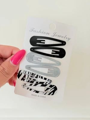 6-pack hårspännen i svart, silver & zebra - Snyggt 6-pack hårspännen i olika stilar: två svarta, två glittriga silver och två med zebramönster. Perfekta för att piffa upp frisyren och hålla håret på plats. Klassisk klick-modell som är enkel att använda.