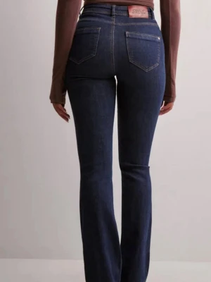 Mörkblå bootcut jeans från ONLY - Snygga mörkblå bootcut jeans från ONLY med hög midja. Jeansen har en figurnära passform upptill och lätt utsvängda ben. Tillverkade i stretchigt denimtyg.🤗