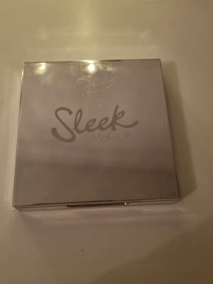 Sleek MakeUP ögonskuggspalett - Snygg ögonskuggspalett från Sleek MakeUP med fem skimrande nyanser i guld, champagne, lila, silver och beige. Kommer i en stilren, spegelblank ask med inbyggd spegel. Perfekt för att skapa kreativa och glammiga ögonlooks.