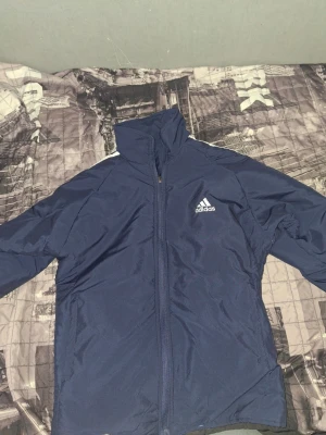 Adidas dubbelsidig tracksuit i blått - En helt ny blå Adidas tracksuit som är dubbelsidig och man kan ändra färg på den genom att byta sida på den och det kommer ett fina par byxor med den som är mörkblå.