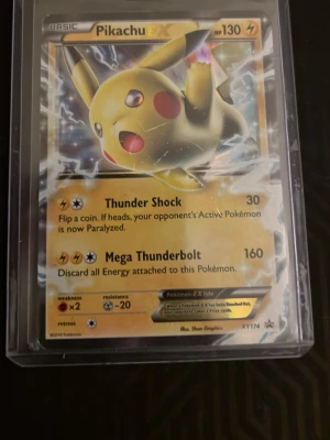 Pikachu EX Pokémonkort XY174 - Säljer ett Pikachu EX samlarkort från Pokémon, nummer XY174. Kortet har guldfärgad ram och motiv av Pikachu med blixtar. Kortet är på engelska och ligger i ett plastfodral. Perfekt för samlare eller Pokémon-fans.