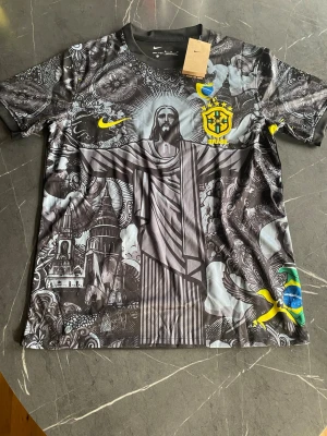 Nike Brasil Dri-Fit t-shirt M - Säljer en Nike Brasil Dri-FIT tröja i storlek M.  Riktigt snygg och ovanlig modell med detaljerat svart/grått motiv framtill med Cristo Redentor, CBF/Brasil-märke och gula/gröna detaljer. Svart baksida med Brasil-märke upptill och mönstrade ärmar.  Storlek: M Märke: Nike Modell: Dri-FIT Färg: Svart / grå / gul / grön Skick: Ny med tags enligt bilder  Perfekt för samlare, Brasilien-supporter eller dig som vill ha en annorlunda Nike-tröja.  Se bilder för egen bedömning av modell, färg och skick.