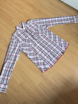 Jack & Jones rutig skjorta strl L – vintage - Snygg rutig skjorta från Jack & Jones i vitt, rosa och mörka detaljer. Modell “Vintage Denim” med tryckknappar och dubbla bröstfickor. Perfekt till både vardag och en mer uppstyrd outfit.  Storlek: L Skick: Bra skick utan större anmärkningar.  Modellen på bilden är ca 185 cm lång och väger ca 78 kg för referens. Skjortan sitter mer som M/L i passformen.  Hör gärna av dig vid frågor eller intresse!