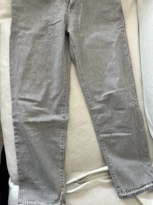 Gråa dad jeans från Pull&Bear - Snygga gråa dad jeans från Pull&Bear med rak passform och klassisk femficksdesign. Jeansen har en avslappnad look och är tillverkade i bomull. Perfekta för en trendig och bekväm stil.